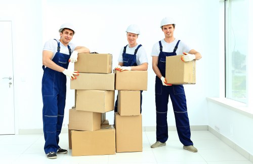 Professional movers carrying furniture through a North London flat entrance